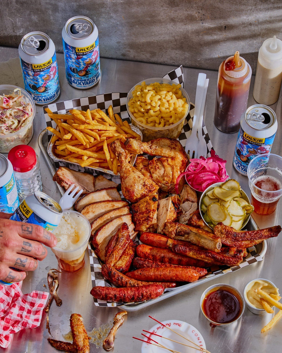 Mixed grill platter with sausages, glazed pork belly and chicken carved on a wooden board