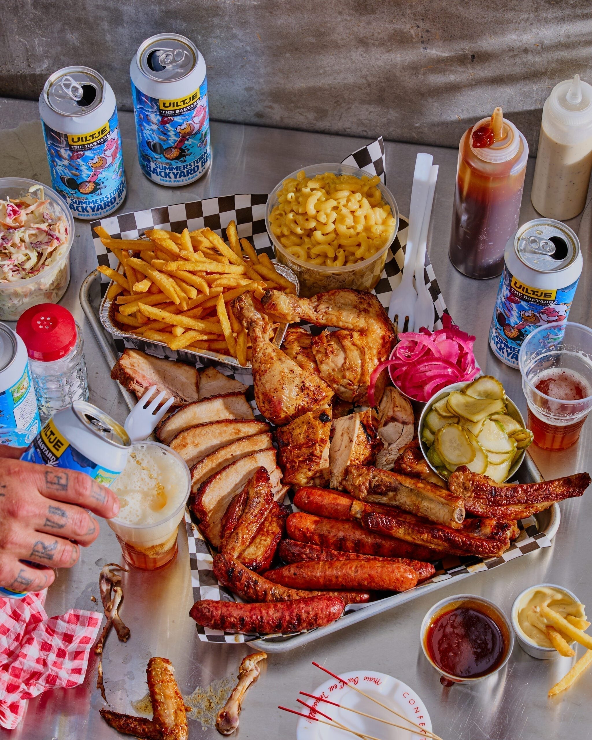 Mixed grill platter with sausages, glazed pork belly and chicken carved on a wooden board