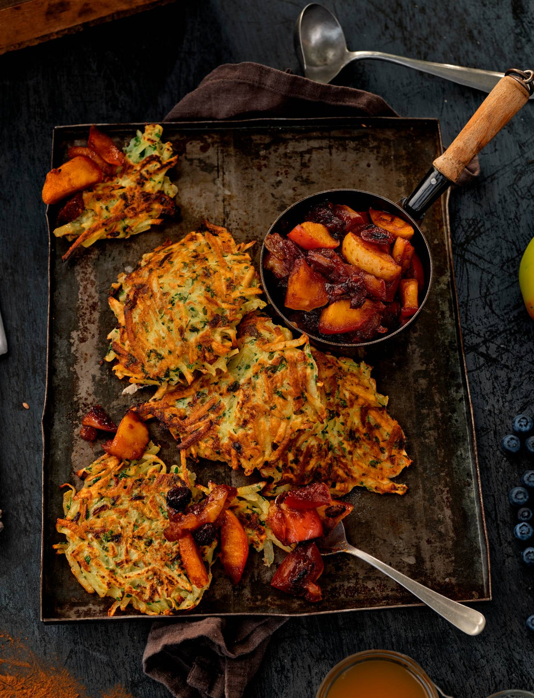 Crispy Reibekuchen potato pancakes with homemade apple compote in a small pan