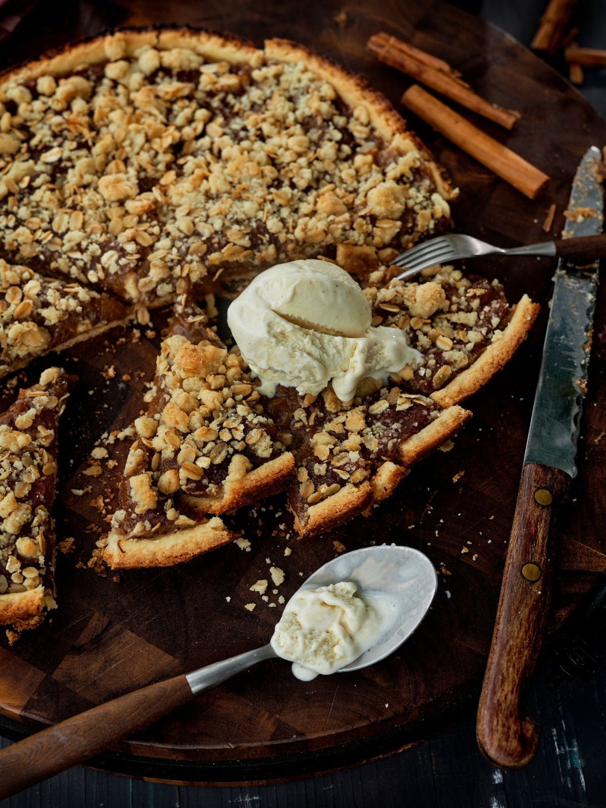 Rhubarb crumble tart cut into slices with a scoop of vanilla ice cream
